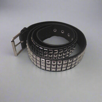 Black studded belt on a gray surface with clothes in the background